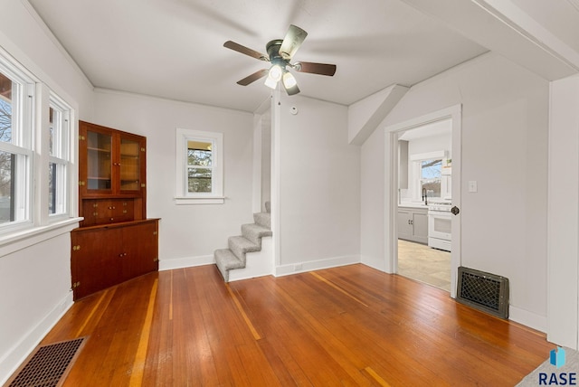 spare room with hardwood / wood-style flooring, ceiling fan, and a healthy amount of sunlight