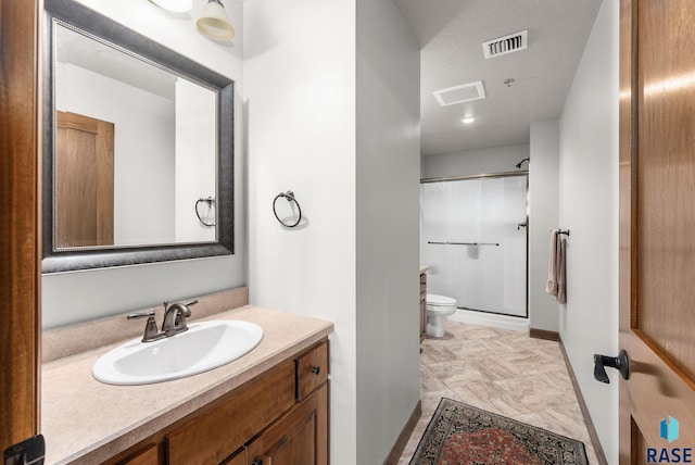 bathroom featuring vanity, toilet, and walk in shower