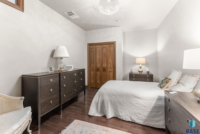 bedroom with dark wood-type flooring and a closet