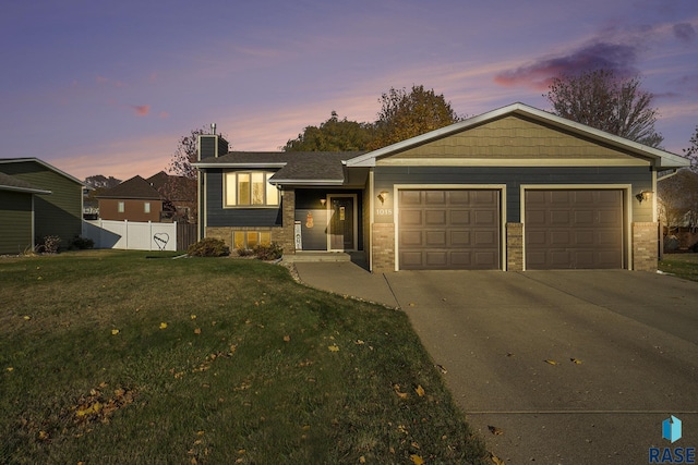 view of front of property with a garage and a lawn