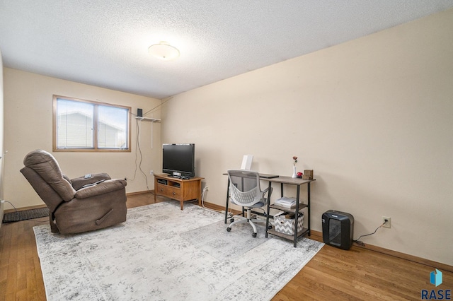 home office featuring hardwood / wood-style flooring and a textured ceiling