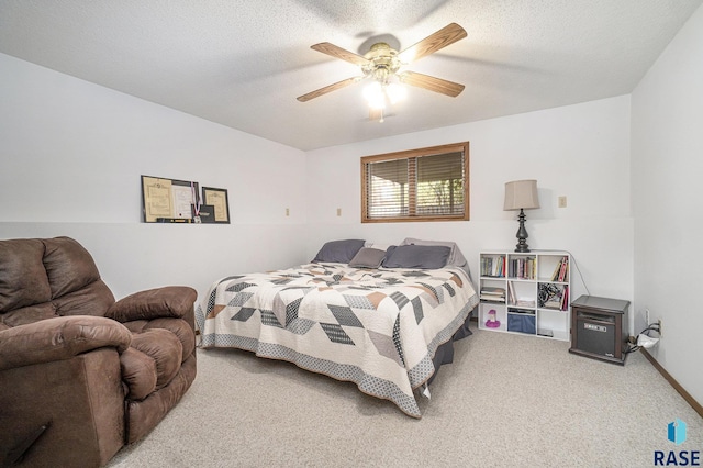 carpeted bedroom with ceiling fan and a textured ceiling