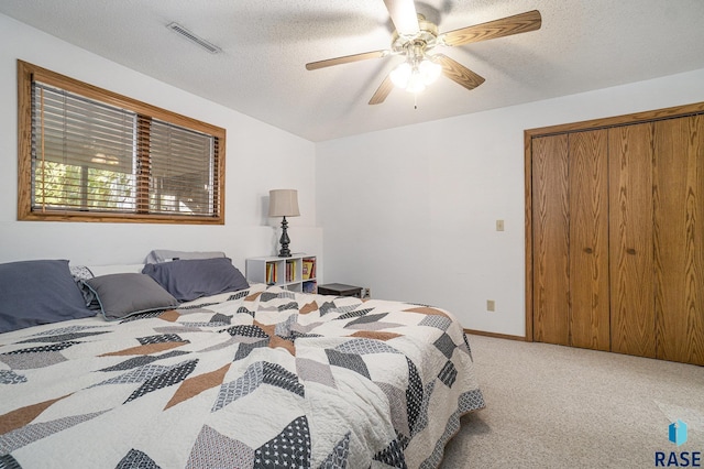 bedroom featuring ceiling fan, carpet flooring, a textured ceiling, and a closet