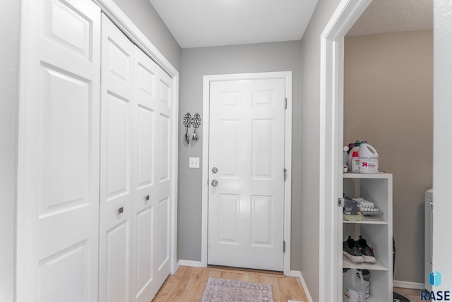 doorway to outside featuring light hardwood / wood-style floors and a textured ceiling