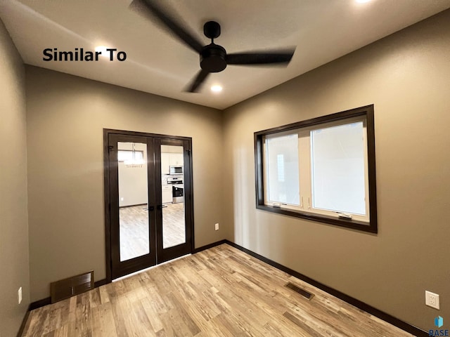 spare room featuring french doors, plenty of natural light, and light hardwood / wood-style flooring