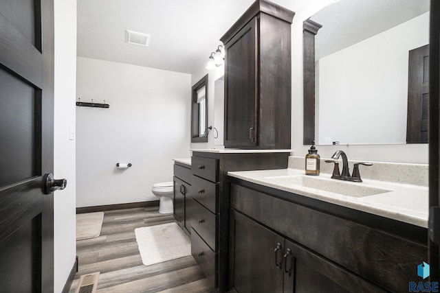 bathroom with vanity, hardwood / wood-style floors, and toilet