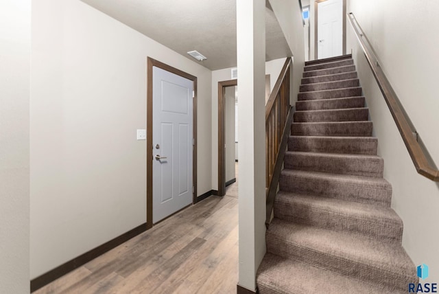 stairway with hardwood / wood-style floors