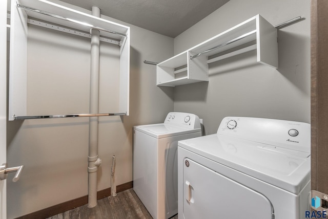 laundry room featuring dark hardwood / wood-style flooring, washer and dryer, and a textured ceiling