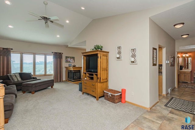 carpeted living room with ceiling fan and vaulted ceiling