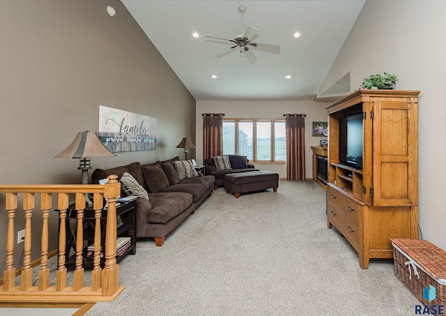 living room with ceiling fan, light colored carpet, and high vaulted ceiling