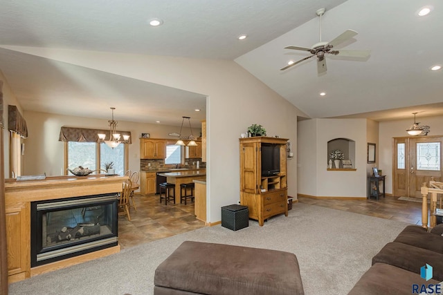 living room featuring ceiling fan with notable chandelier, lofted ceiling, carpet floors, and sink