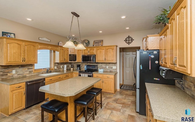 kitchen featuring sink, a kitchen island, stainless steel appliances, a kitchen bar, and decorative light fixtures