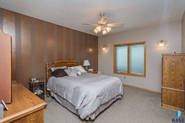 carpeted bedroom featuring ceiling fan and a textured ceiling