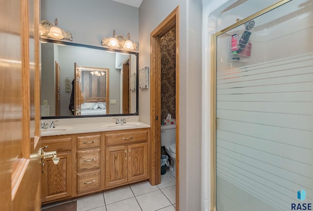 bathroom with tile patterned flooring, vanity, a shower with shower door, and toilet