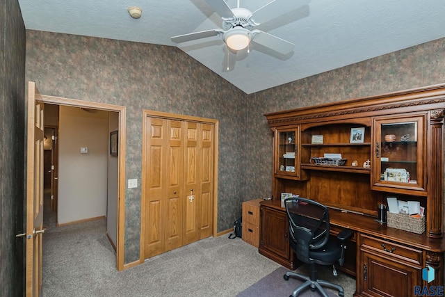 carpeted home office with vaulted ceiling, a textured ceiling, and ceiling fan