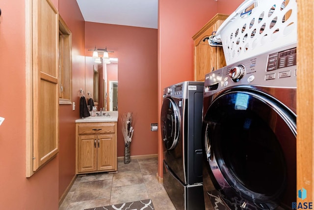 laundry area featuring cabinets, sink, and washing machine and clothes dryer