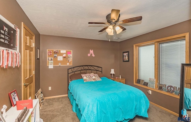 bedroom with light colored carpet, a textured ceiling, and ceiling fan