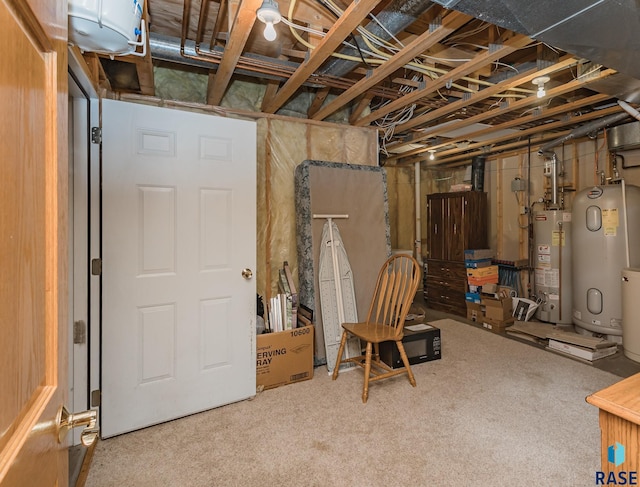 basement featuring gas water heater, carpet, and electric water heater