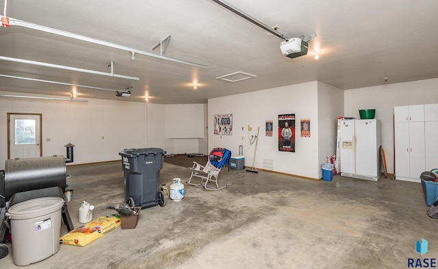 garage featuring a garage door opener and white refrigerator with ice dispenser