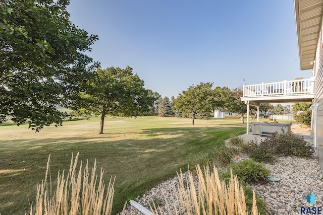 view of yard with a hot tub and a deck