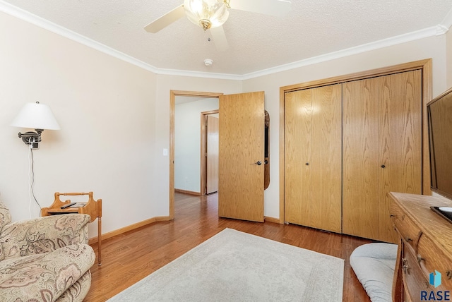 sitting room featuring ceiling fan, crown molding, light hardwood / wood-style floors, and a textured ceiling