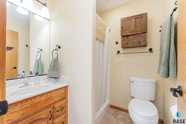 bathroom with vanity, tile patterned flooring, toilet, and walk in shower