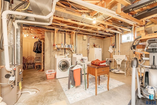 basement featuring washing machine and dryer and white fridge