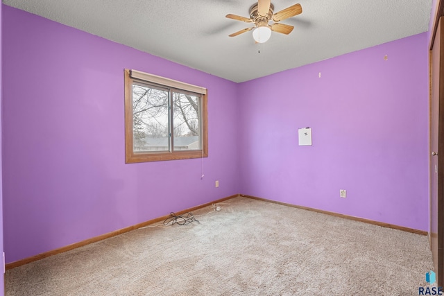 empty room with ceiling fan, carpet floors, and a textured ceiling