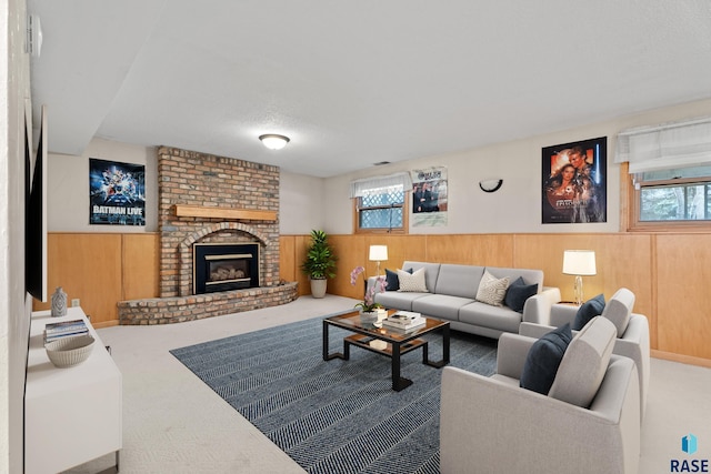 carpeted living room featuring a textured ceiling, a fireplace, and wood walls