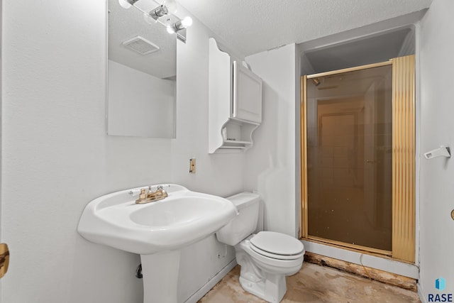 bathroom featuring an enclosed shower, a textured ceiling, and toilet