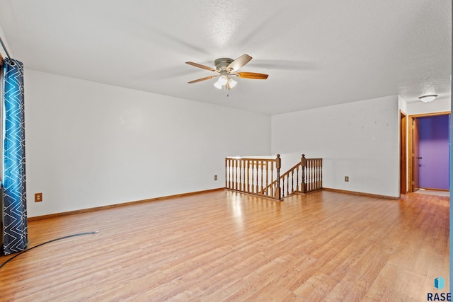 spare room featuring ceiling fan, light hardwood / wood-style floors, and a textured ceiling