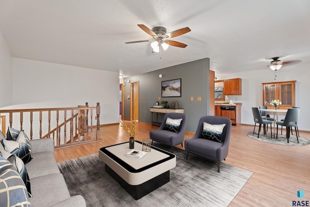 living room with ceiling fan, hardwood / wood-style floors, and a textured ceiling