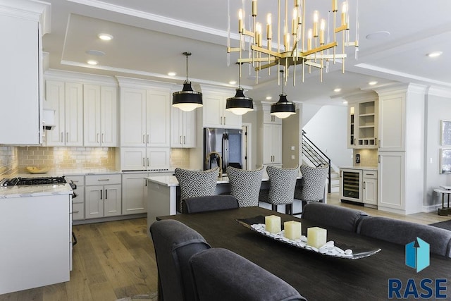 interior space with crown molding, hardwood / wood-style floors, and beverage cooler