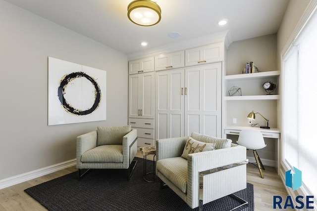 sitting room featuring built in desk and light hardwood / wood-style floors