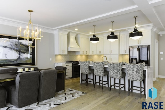 kitchen with black gas range oven, decorative light fixtures, a kitchen breakfast bar, stainless steel refrigerator with ice dispenser, and custom range hood