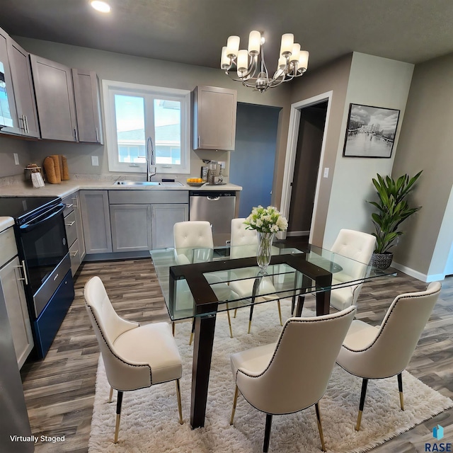 dining space with dark hardwood / wood-style flooring, sink, and an inviting chandelier