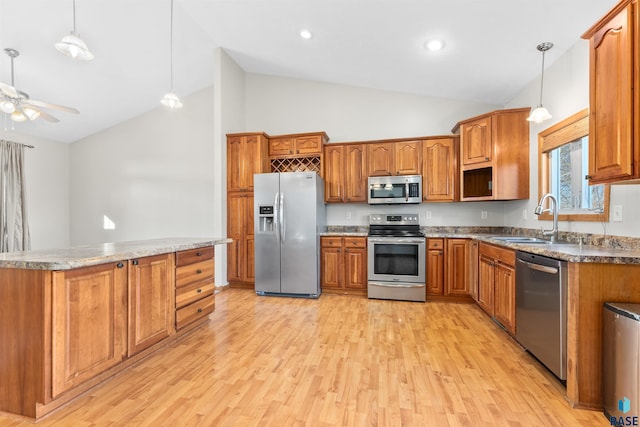 kitchen featuring sink, light hardwood / wood-style flooring, appliances with stainless steel finishes, pendant lighting, and ceiling fan