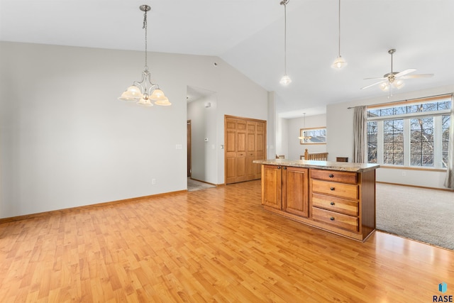 kitchen with high vaulted ceiling, ceiling fan with notable chandelier, hanging light fixtures, and light hardwood / wood-style flooring