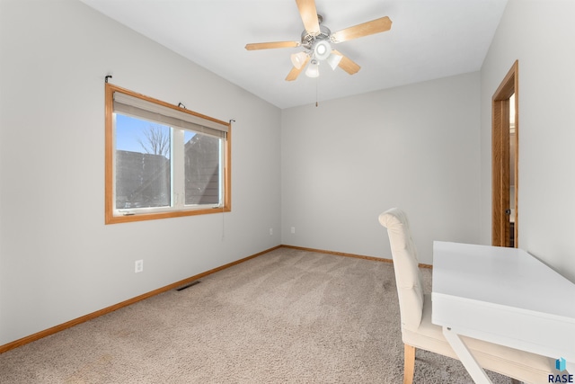 unfurnished office featuring ceiling fan and carpet