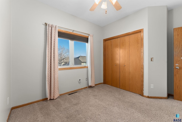 unfurnished bedroom with light colored carpet, ceiling fan, and a closet