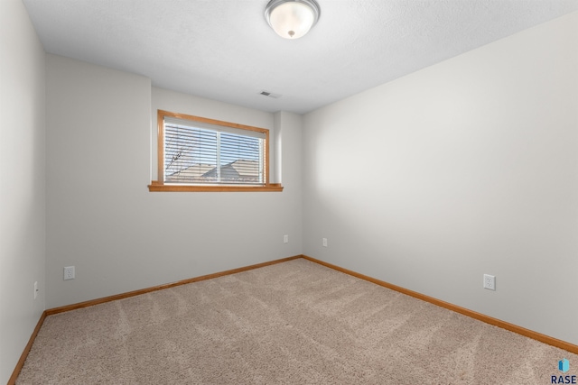 empty room with carpet floors and a textured ceiling