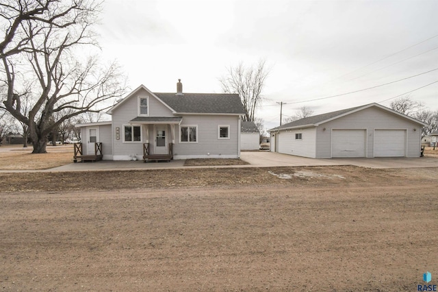 view of front of home with a garage, an outdoor structure, and a front yard