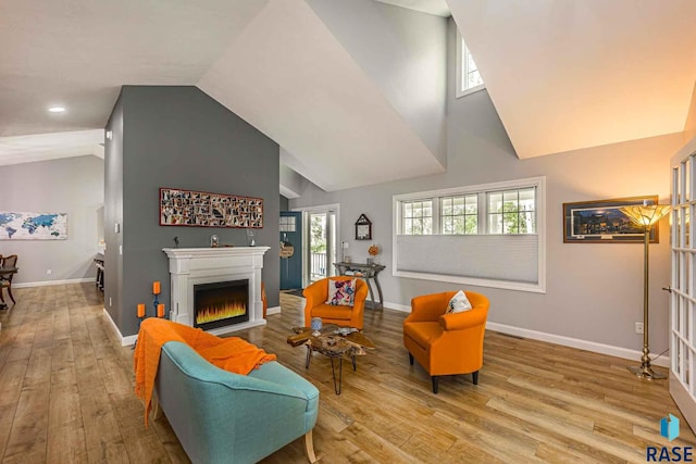 living room with high vaulted ceiling and light wood-type flooring