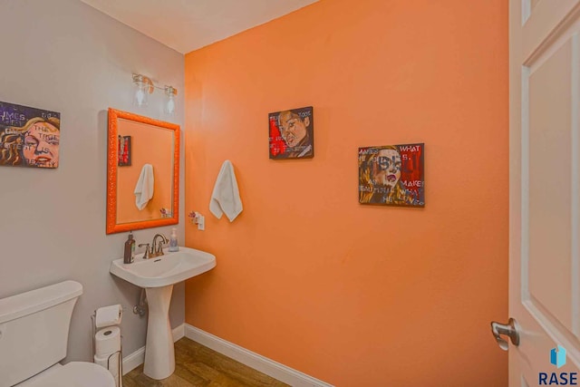 bathroom with toilet and hardwood / wood-style floors