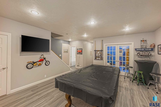 playroom with wood-type flooring, french doors, and a textured ceiling