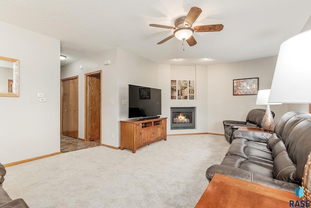 living room with ceiling fan, light colored carpet, and a textured ceiling