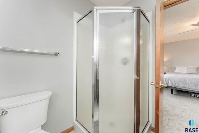 bathroom with a textured ceiling, toilet, and walk in shower