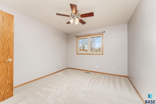 empty room with ceiling fan, a textured ceiling, and carpet flooring