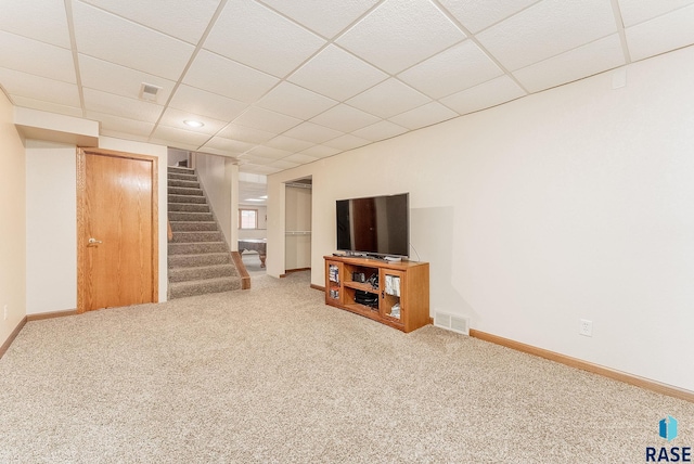 basement featuring a paneled ceiling and carpet