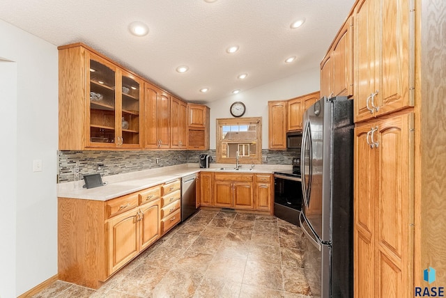 kitchen with vaulted ceiling, stainless steel appliances, sink, and tasteful backsplash